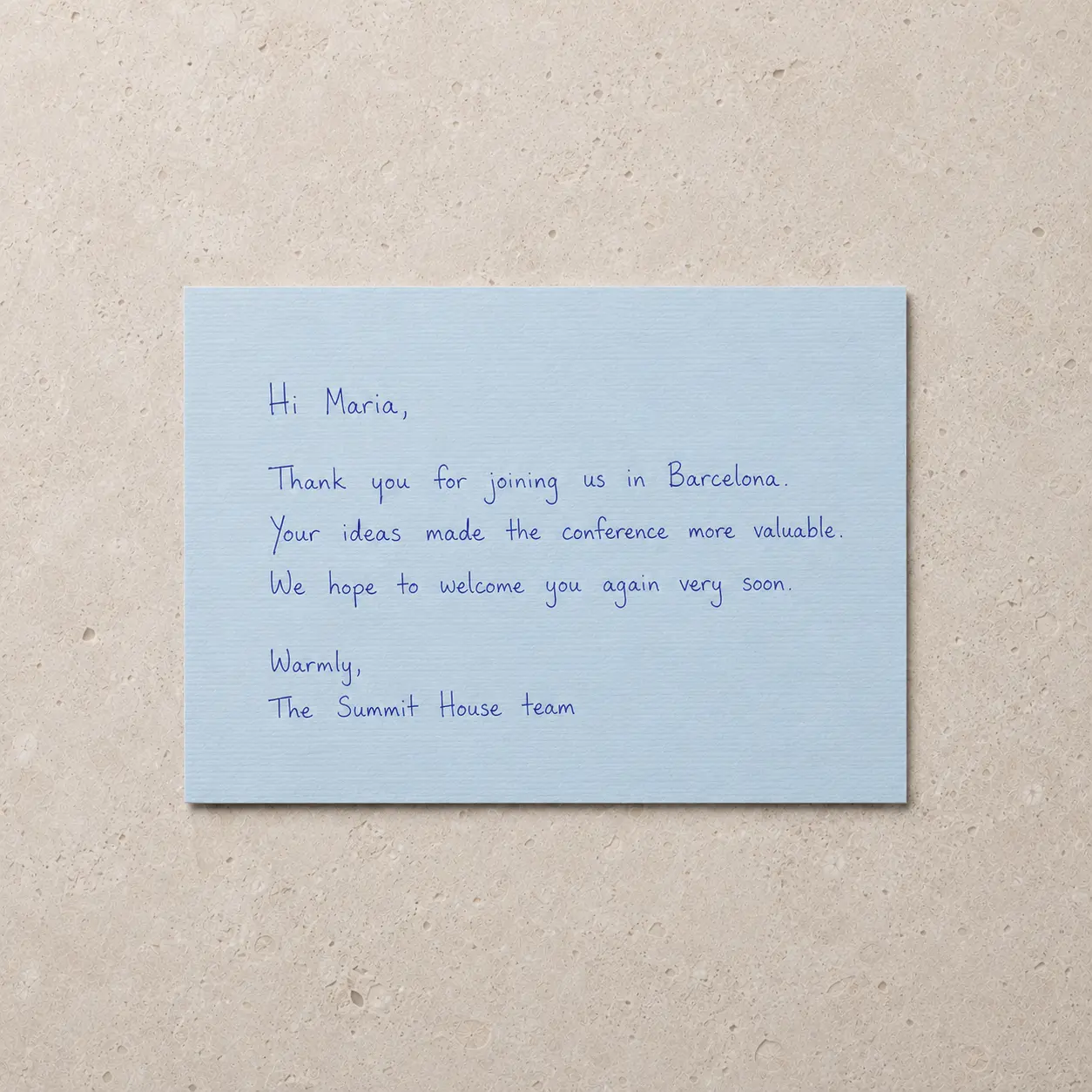 Tarjeta azul escrita con pluma en tinta azul: «Hi Maria, thank you for joining us in Barcelona».