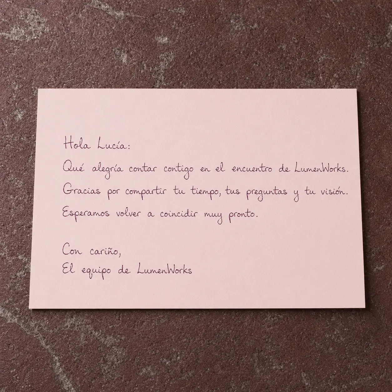 Tarjeta rosa con nota de agradecimiento tras un encuentro corporativo, escrita en tinta marrón.